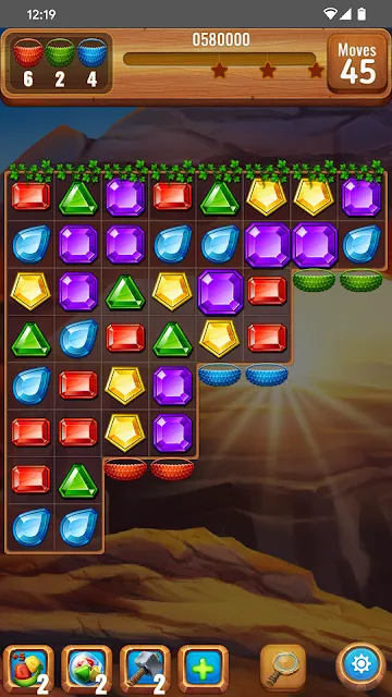 A full grid of cut gems over a canyon background, with three objective counters in the header